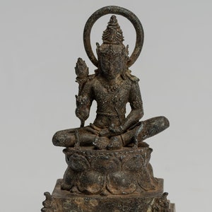 Pode incluir: Uma estátua de bronze de um Buda sentado com um halo e uma base de lótus. A estátua está em uma postura meditativa com as mãos no colo.