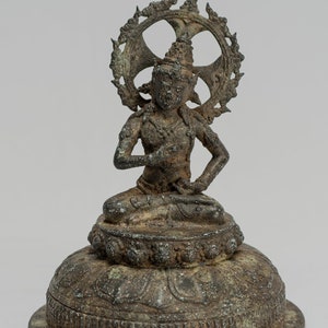 May include: A bronze statue of a seated deity with a halo, possibly a Buddha or Bodhisattva, on a lotus base. The statue is in a meditative pose with hands in the lap.