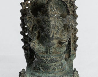 May include: A small, green bronze statue of a deity seated on a throne. The statue is intricately detailed and has a crown on its head.