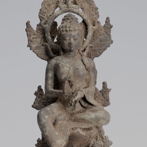 Puede incluir: Una estatua de bronce de un Buda sentado con un halo y detalles intrincados. La estatua está en una postura meditativa con las manos juntas frente al pecho.