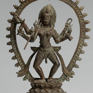 May include: A bronze statue of a Hindu deity with multiple arms, standing in a dancing pose within a circular frame. The statue is on a square base with intricate details.