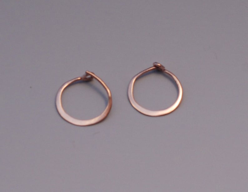 May include: A pair of small, simple, gold hoop earrings.