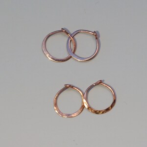 May include: Four hammered gold hoop earrings. Two larger hoops and two smaller hoops.