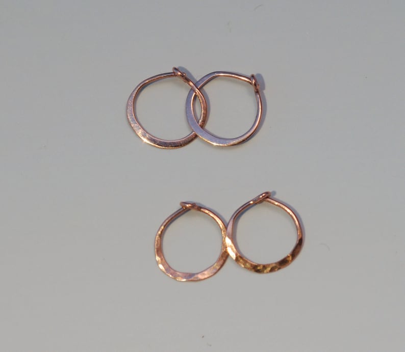 May include: Four hammered gold hoop earrings. Two larger hoops and two smaller hoops.