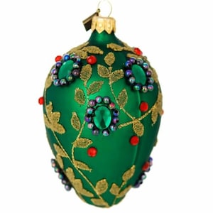 May include: Green Christmas ornament with gold leaf design, red and iridescent accents. The ornament has a teardrop shape and a gold metal cap for hanging. A festive holiday decoration.