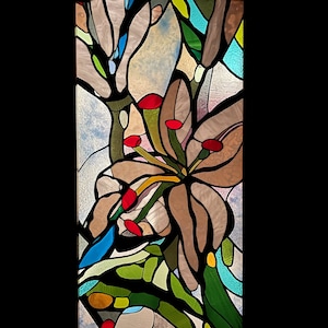 Puede incluir: Una ventana de vitrales que representa un diseño floral estilizado en tonos marrones, azules, verdes y rojos.