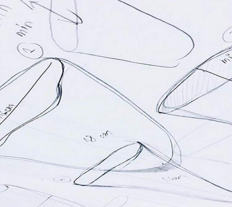 May include: Hand-drawn sketches of different shapes with measurements in centimeters and millimeters. The sketches are on a white piece of paper.
