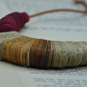 Collana asimmetrica in materiale riciclato rosso scuro, gioiello artigianale.