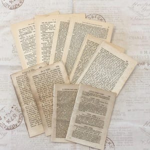 Op de afbeelding: Een verzameling vintage boekpagina's met tekst in verschillende talen, waaronder Frans en Duits. De pagina's zijn verkleurd door de tijd en hebben een versleten, antieke uitstraling. Sommige pagina's hebben decoratieve randen of illustraties.
