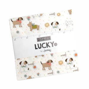 May include: A stack of fabric squares with a dog-themed pattern. The fabric features cartoon dogs with bandanas and bow ties, along with the word "woof" and floral accents. The fabric is labeled "LUCKY" by Sweetwater.