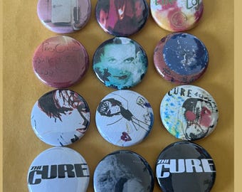 Puede incluir: Doce botones redondos de la banda The Cure con varias portadas de álbumes y logotipos de la banda. Los botones son blanco y negro, rojo y blanco, azul y blanco, y multicolores.