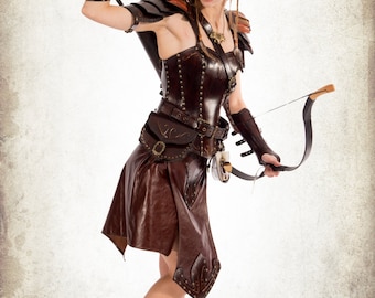 May include: A woman wearing a brown leather costume with a studded bodice, a skirt, and arm guards. She is holding a bow and arrow and has pointed ears. The image is titled "Dracovite".