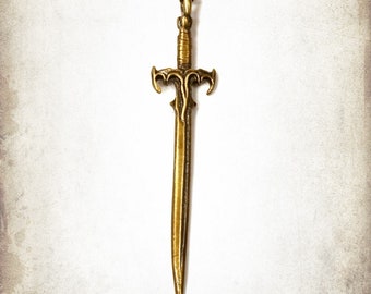 Pode incluir: Um colar com um pingente de espada dourado. A espada tem um design detalhado com uma ponta pontiaguda e uma alça decorativa.