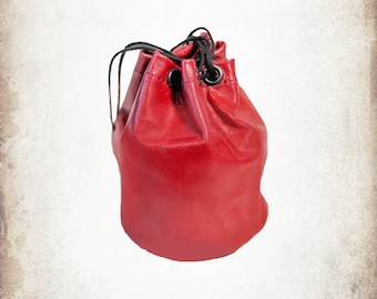 May include: A red leather drawstring bag with a black drawstring and metal eyelets.