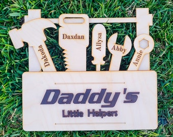 May include: Wooden toolbox with the words "Daddy's Little Helpers" on the front. The toolbox has five tools with names on them: Dakoda, Daxdan, Allyssa, Abby, and Annie.