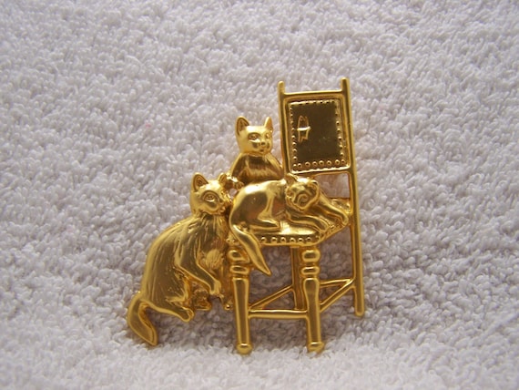 Gold tone brooch has three cats sitting around an… - image 1