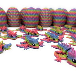 May include: A collection of colorful, rainbow-striped lizard figurines and egg-shaped objects. The lizards are in various poses, with vibrant hues of blue, green, yellow, and pink. The eggs have a similar striped pattern.