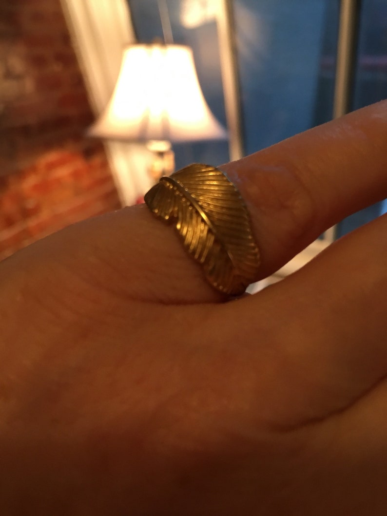 May include: A gold ring with a feather design.