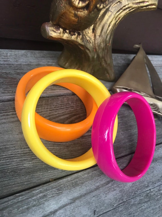 A grouping of 3 Cheerful Resort Citrus Rainbow Colored Plastic Bangle Bracelets