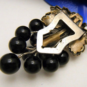 back side of art deco dress clip showing brass fold over clip