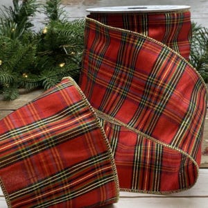 May include: A roll of red plaid ribbon with gold trim. The ribbon features a classic tartan pattern in red, green, black, and gold. The ribbon is ideal for holiday decorations and gift wrapping.