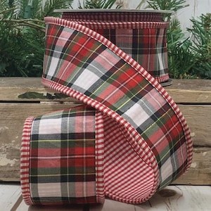 Op de afbeelding: Een rol decoratief lint met een klassiek ruitpatroon in rood, groen, zwart en wit. De rand van het lint heeft een rood-wit gestreept ontwerp. Perfect voor knutselen en cadeauverpakking.