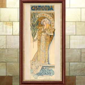 May include: Framed vintage art print of a woman in a flowing gown, holding a sprig of leaves. The artwork features the text "GISMONDA BERNHARDT" and "THEATRE RENAISSANCE" in ornate lettering, with a color palette of gold, blue, and cream.