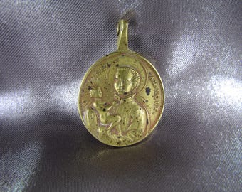 Puede incluir: Un colgante de metal dorado con una imagen religiosa de San Antonio de Padua sosteniendo a un bebé Jesús. El colgante tiene un bucle en la parte superior para colgar.