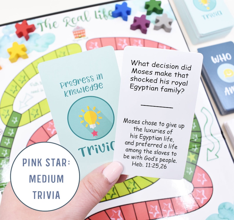 K&ouml;nnte beinhalten: Eine rosa sternf&ouml;rmige Karte mit dem Text "PINK STAR: MEDIUM TRIVIA" und eine hellblaue Karte mit dem Text "Progress in Knowledge" und einem Gl&uuml;hbirnen-Symbol. Die hellblaue Karte wird in einer Hand gehalten. Der Text auf der hellblauen Karte lautet "Welche Entscheidung traf Moses, die seine k&ouml;nigliche &auml;gyptische Familie schockierte?" und "Moses entschied sich, den Luxus seines &auml;gyptischen Lebens aufzugeben und ein Leben unter den Sklaven zu w&auml;hlen, um mit Gottes Volk zu sein. Heb. 11:25,26".