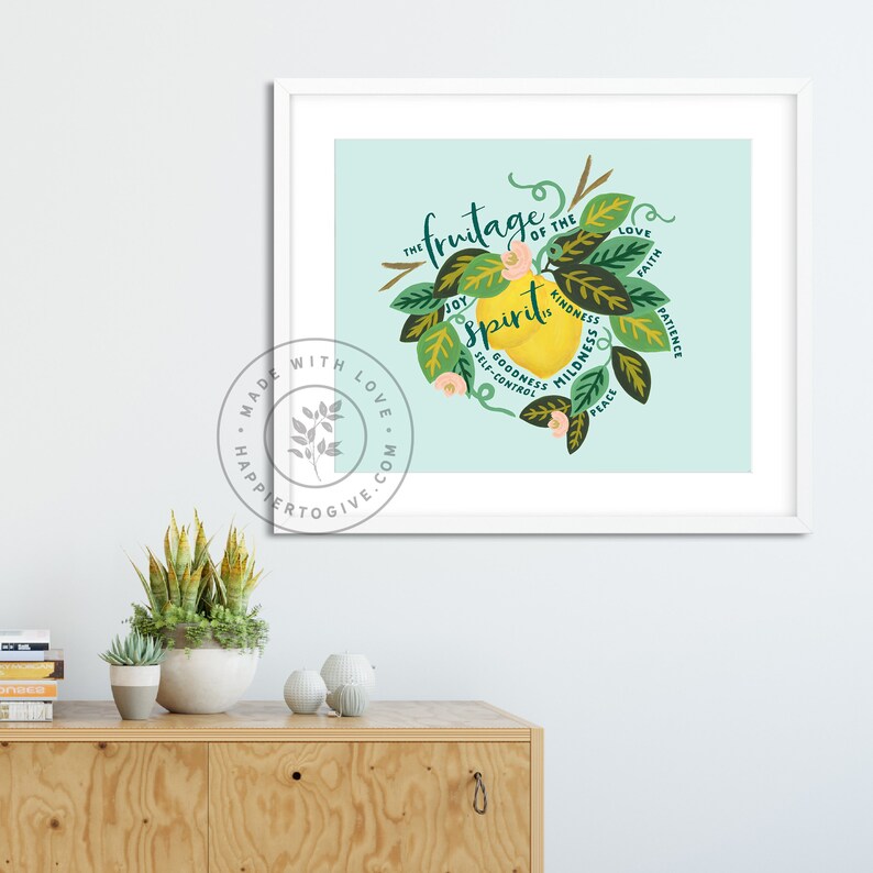 May include: A light blue background with a yellow lemon illustration. The lemon has green leaves and flowers around it. The text "The fruitage of the spirit" is written in a circle around the lemon. The words "love, faith, patience, peace, kindness, mildness, goodness, self-control, joy" are written around the lemon.