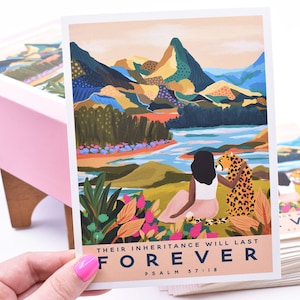 May include: A postcard with a colorful illustration of a woman sitting with a cheetah in front of a mountain range and a lake. The text on the postcard reads "Their inheritance will last FOREVER Psalm 57:18".