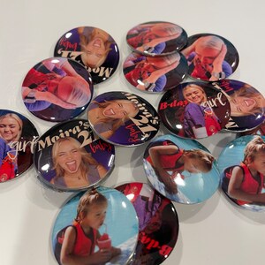 May include: A collection of round buttons with various images and text. The buttons feature a young woman with a red and white birthday hat, a young girl in a pool, and a young woman with a tongue sticking out. The text on the buttons includes "Moira's 21st", "B-day girl", and "Moira's 21st baby".
