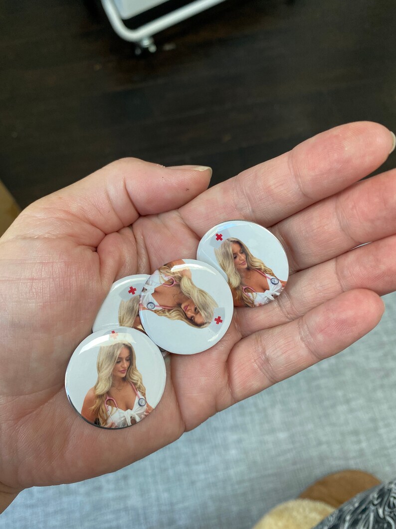 May include: Four round white buttons with a red cross in the top right corner. Each button features a photo of a woman wearing a white nurse's uniform and a stethoscope.