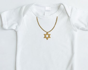 May include: White baby onesie with a gold chain and a gold Star of David pendant.