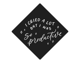 May include: Black graduation cap with white text that reads "I cried a lot but I was so productive".