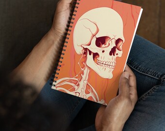 May include: A spiral bound notebook with a colorful illustration of a human skeleton with a skull on an orange background.