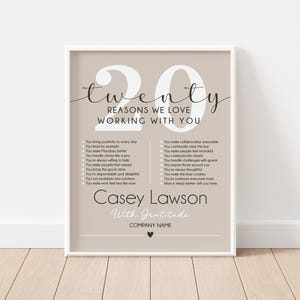 May include: Framed print with the text "Twenty Reasons We Love Working With You." The print has a neutral color scheme with a list of positive attributes. The name "Casey Lawson" is featured at the bottom, along with "With Gratitude."