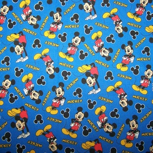 May include: Blue fabric featuring a repeating pattern of Mickey Mouse in various poses. Mickey is wearing his signature red shorts, yellow shoes, and white gloves. The word "MICKEY" is printed in yellow.