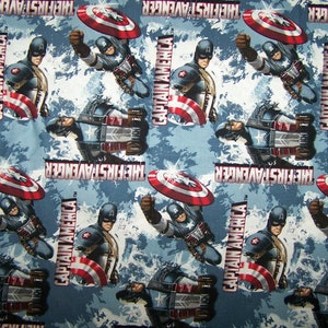 Puede incluir: Una tela azul y blanca con un patrón repetido de Capitán América. El patrón incluye las palabras "Capitán América" y "The First Avenger".