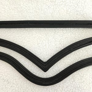 May include: Three black leather horse reins with buckles and stitching. The reins are arranged in a V-shape.