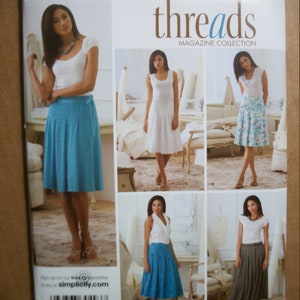 May include: A sewing pattern for a skirt, Simplicity pattern number 3841, with a white background and the text "Simplicity" and "threads MAGAZINE COLLECTION". The pattern includes four different skirt styles, with a model wearing each style.