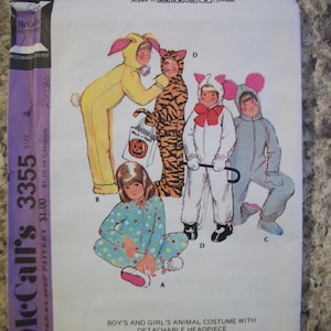 May include: A vintage McCall's sewing pattern for children's animal costumes. The pattern features illustrations of kids in bunny, tiger, cat, and mouse costumes. The pattern includes a detachable headpiece. The text "Make it EASY, please" is visible.