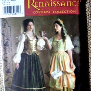 May include: A Simplicity Renaissance Costume Collection sewing pattern envelope, number 3809, size D. The front displays two historical-style dresses with long skirts, bodices, and puffed sleeves, one in dark green and gold, the other in light green and peach.