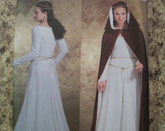 May include: A Butterick pattern envelope featuring illustrations of a medieval-style dress and hooded cloak. The dress is white with long sleeves and a cinched waist. The cloak is dark red with a white lining. The pattern number is 34377.