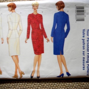 May include: A Butterick sewing pattern envelope featuring illustrations of long-sleeved, knee-length dresses. The designs include a solid white dress, a red dress with a dark leaf pattern, and a solid blue dress, all shown from front and back views.