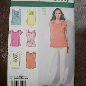 May include: A sewing pattern for a sleeveless top with a ruffled neckline. The pattern includes separate patterns for different cup sizes. The pattern number is 2599 and the sizes are 12, 14, 16, and 18. The pattern is from Simplicity.
