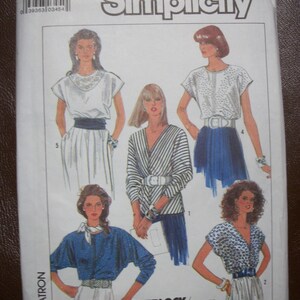 May include: A vintage Simplicity sewing pattern packet featuring illustrations of women's clothing designs. The packet includes the number 3436 and the word "Simplicity" in a bold font. The designs include blouses, skirts, and a jacket.