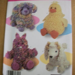 May include: Simplicity pattern featuring four plush toy designs: a bear, duck, bunny, and poodle. The toys are made with textured yarn in various colors, including purple, yellow, and pink. The pattern number is 3933.
