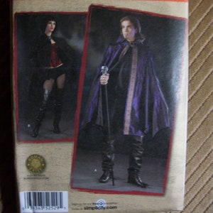 May include: Simplicity sewing pattern featuring costume designs. The package shows a person in a purple cape with gold trim and a person in a black outfit. The pattern number is 2529.