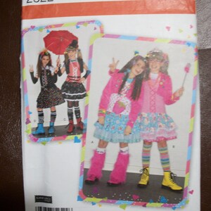 May include: Simplicity sewing pattern 2522, featuring images of girls in colorful outfits. The pattern includes sizes A 7, 8, 10, 12, and 14. The cover has a white background with colorful accents and the Simplicity logo.